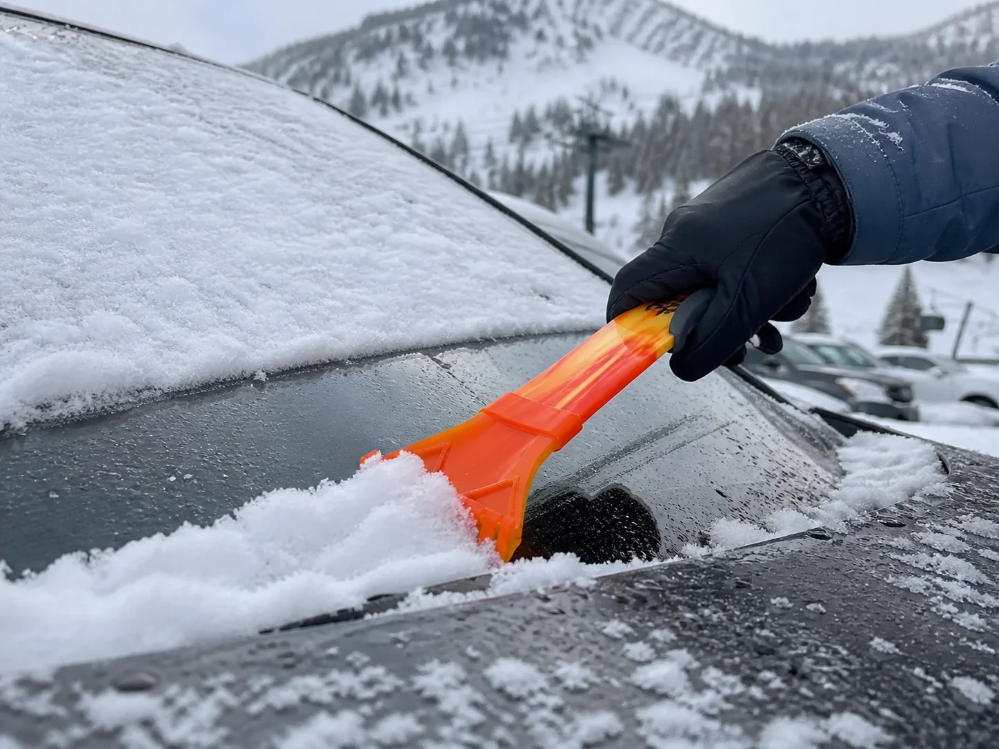 A Ski Scraper clearing a frozen windscreen at first light.