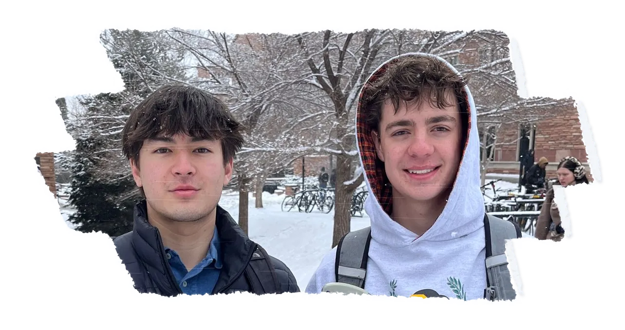 Two people side by side on a snowy campus path, one in a white hood, bare trees behind them.