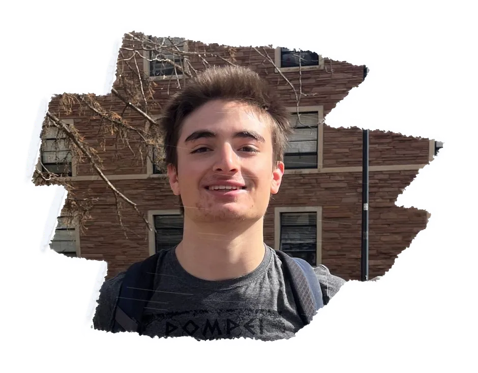 Someone with a backpack smiling, a brick building behind them.