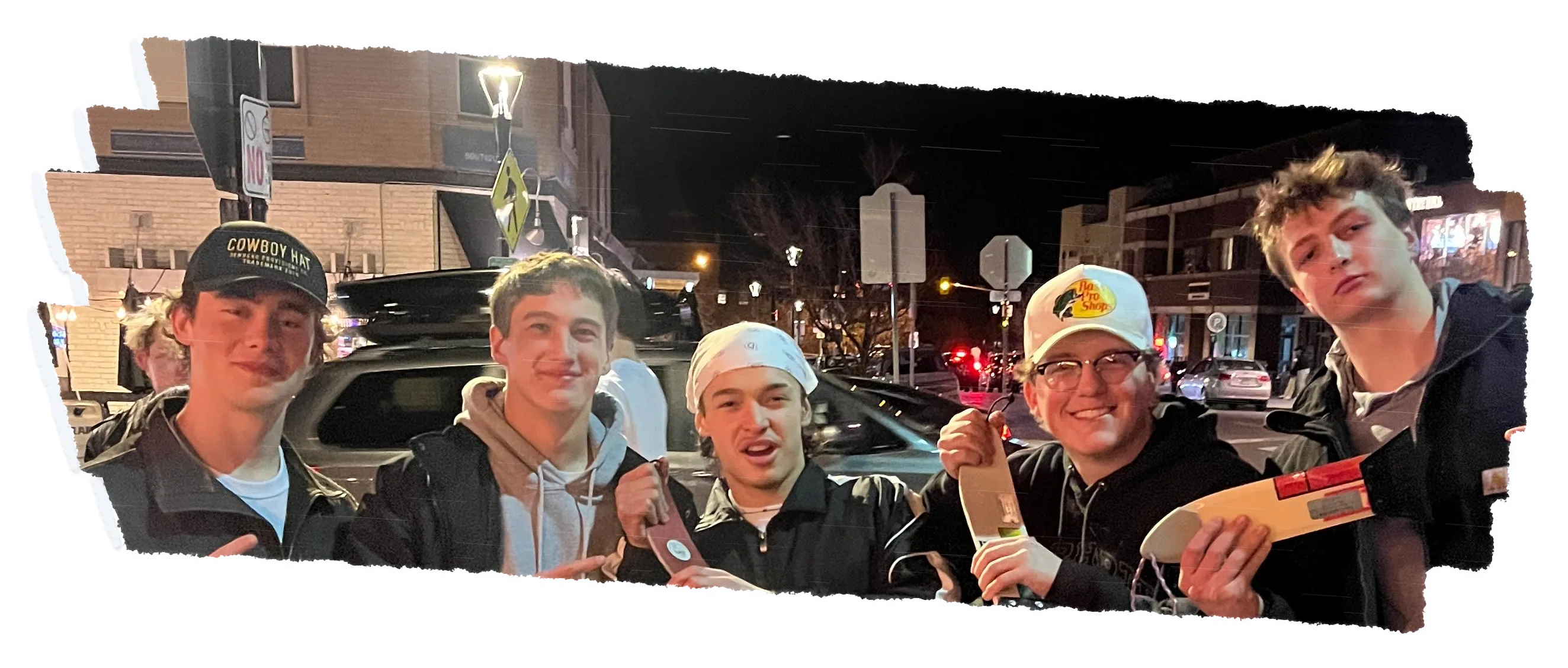 Five people in a row at night, in caps and a bandana, holding scrapers.
